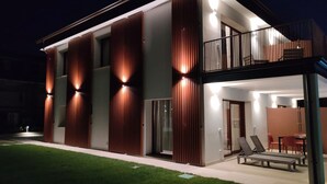A modern two-story house with a balcony, large windows, and a well-maintained lawn. - Gardaliva 7 by the lake in Manerba (Manerba del Garda)