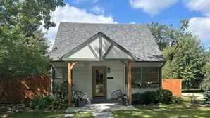 A single-story house with a gabled roof, a front porch, and a pathway leading to the entrance.