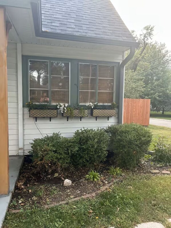 A house with a sloped roof, a window with a wooden frame, and a wooden fence. - Contemporary Cottage 5 min walk to major bike path (Lincoln)