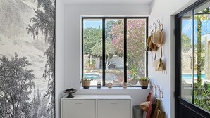 A compact room with a large window, a white cabinet, and a bench. - House N8 Arles - 5mns from the center, seasonal rental in a relaxing setting! (Arles)