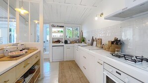 A modern kitchen with white cabinetry, a gas stove, and a dishwasher. - House N8 Arles - 5mns from the center, seasonal rental in a relaxing setting! (Arles)