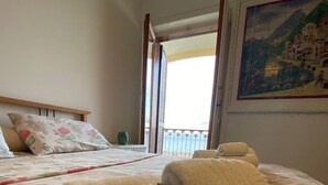 Une chambre d’hôtel avec un lit, deux serviettes enroulées, une décoration en forme de cœur et un tableau au mur.