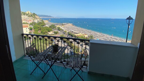Un balcon avec vue sur une plage et sur le paysage urbain.