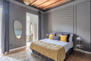 Ein modernes Schlafzimmer mit einem Bett, einem Spiegel und einem Nachttisch.