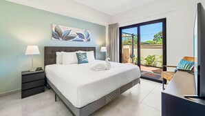 A modern hotel room with a large bed, a desk, and a view of the outdoors. - NEW 2BR/2BA w/Private Jacuzzi minutes from beaches. Gym/Pools/Tennis/Restaurant (Noord)