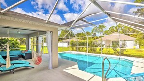 Un espace piscine extérieur abrité, doté d’un coin salon et offrant une vue sur le paysage environnant.