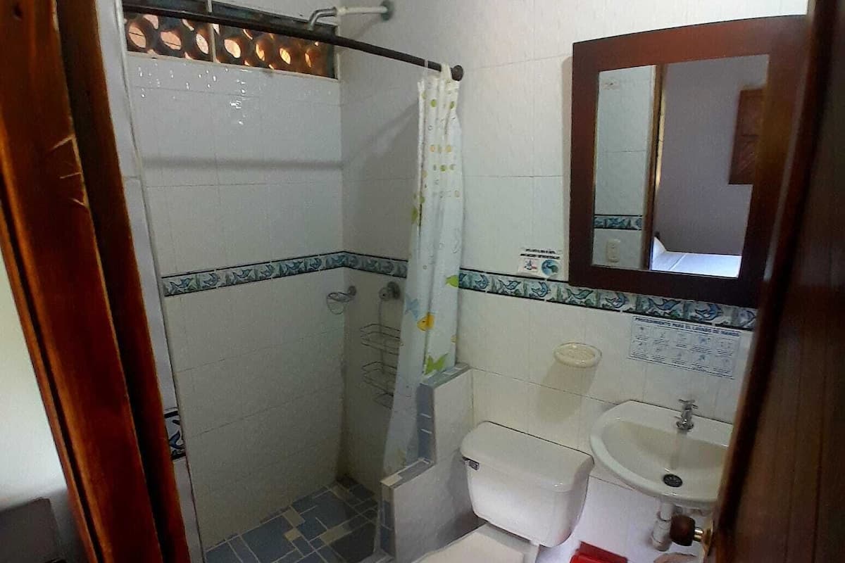 Une petite salle de bain avec une douche, des toilettes et un lavabo.