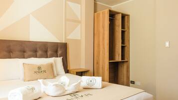 Una habitación de hotel con cama, armario de madera y mesita de noche.