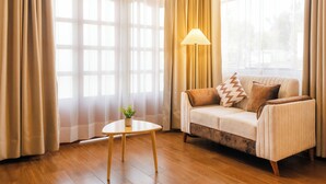 A living room with a sofa, a lamp, and a small table with a plant. - ANDARI HOTELES (Arequipa)
