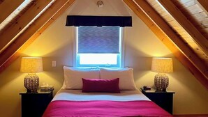 A bedroom with a bed centered under a window, flanked by two nightstands with lamps. - Auberge Aux Quatre Matins (Saint-Côme)