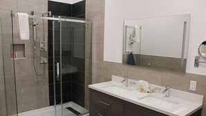 A modern bathroom with a glass-enclosed shower, a double sink vanity, and a large mirror. - Auberge Aux Quatre Matins (Saint-Côme)
