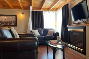 A living room with a fireplace, a television, and a painting on the wall. - Auberge Aux Quatre Matins (Saint-Côme)