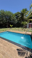 Una piscina techada, sombrillas, sillones reclinables de piscina
