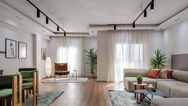 A modern living room with a sofa, chairs, a coffee table, and a floor lamp. - New Cairo Lush & Light (محافظة القاهرة‬)