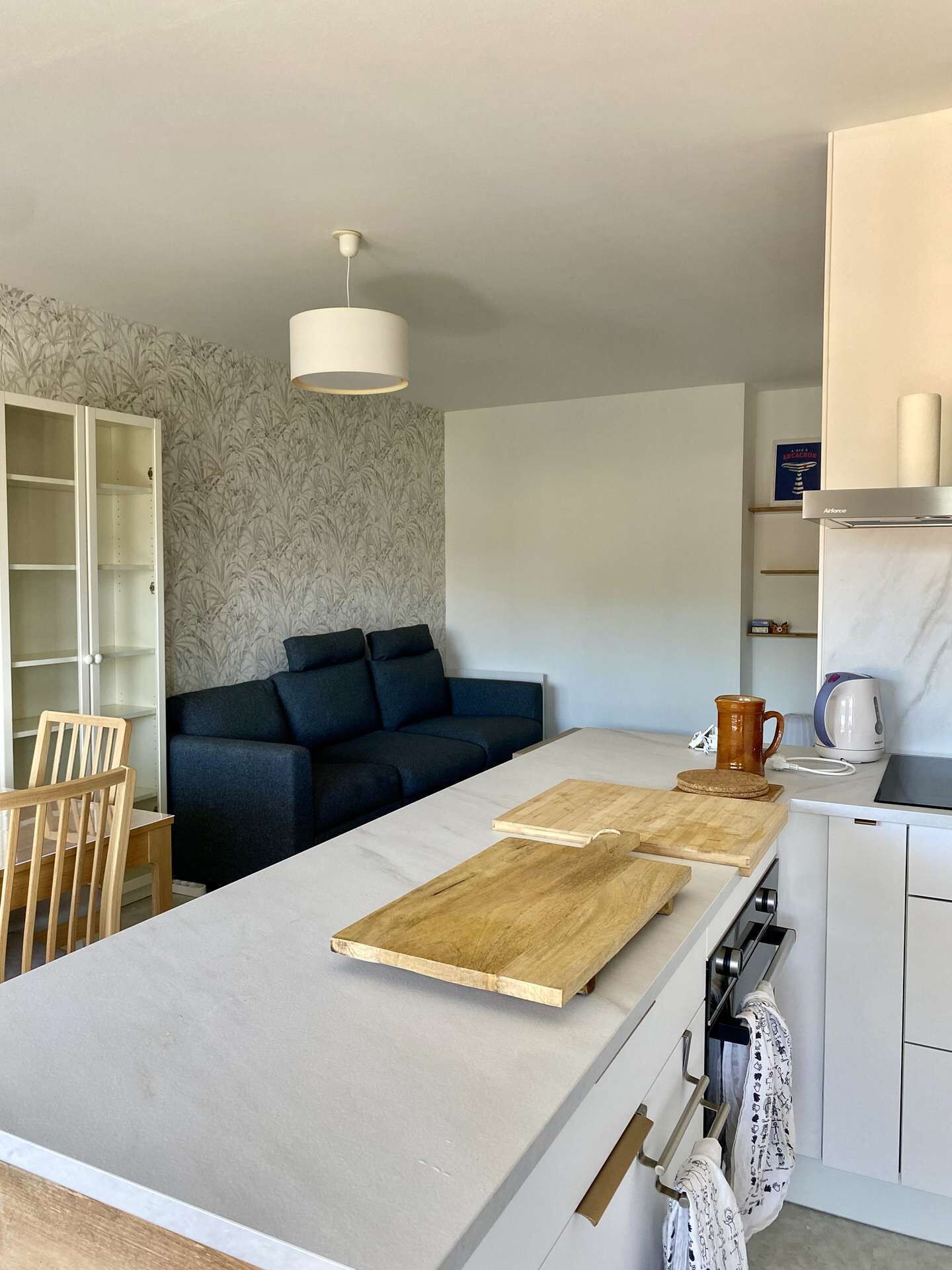 Een moderne keuken met een centraal eiland, een bank en een eethoek.