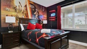 Un dormitorio moderno con una cama grande, cabecera con mural, mesita de noche y ventana con persianas.