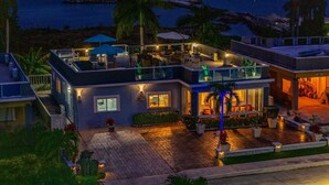 A two-story house with a patio area, outdoor seating, and a pool. - Beachfront with Rooftop Scenic Ocean View 2-bedroom (Saint Ann's Bay)