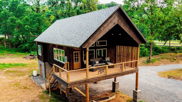 Eine Holzhütte mit Balkon, einer Treppe und einem überdachten Veranda.