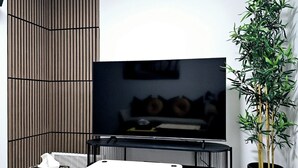 A modern living room with a flat-screen TV, a dining table, a sofa, and a potted plant. - The Luxury Retreat, Calgary

Central location, family oriented, feel at home! (Calgary)