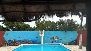 A swimming pool with a mural of marine life on the wall. - “Serene Courtyard Stay – Follow the Path to the Sea” (Chelem)