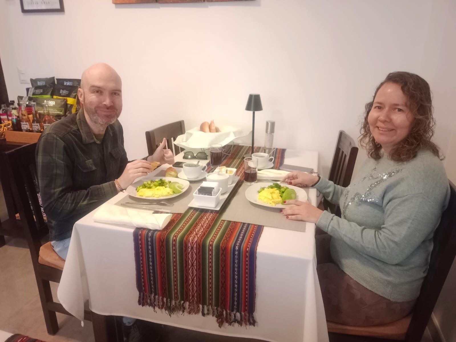Una mesa de comedor con platos de comida, una cafetera y una lámpara.