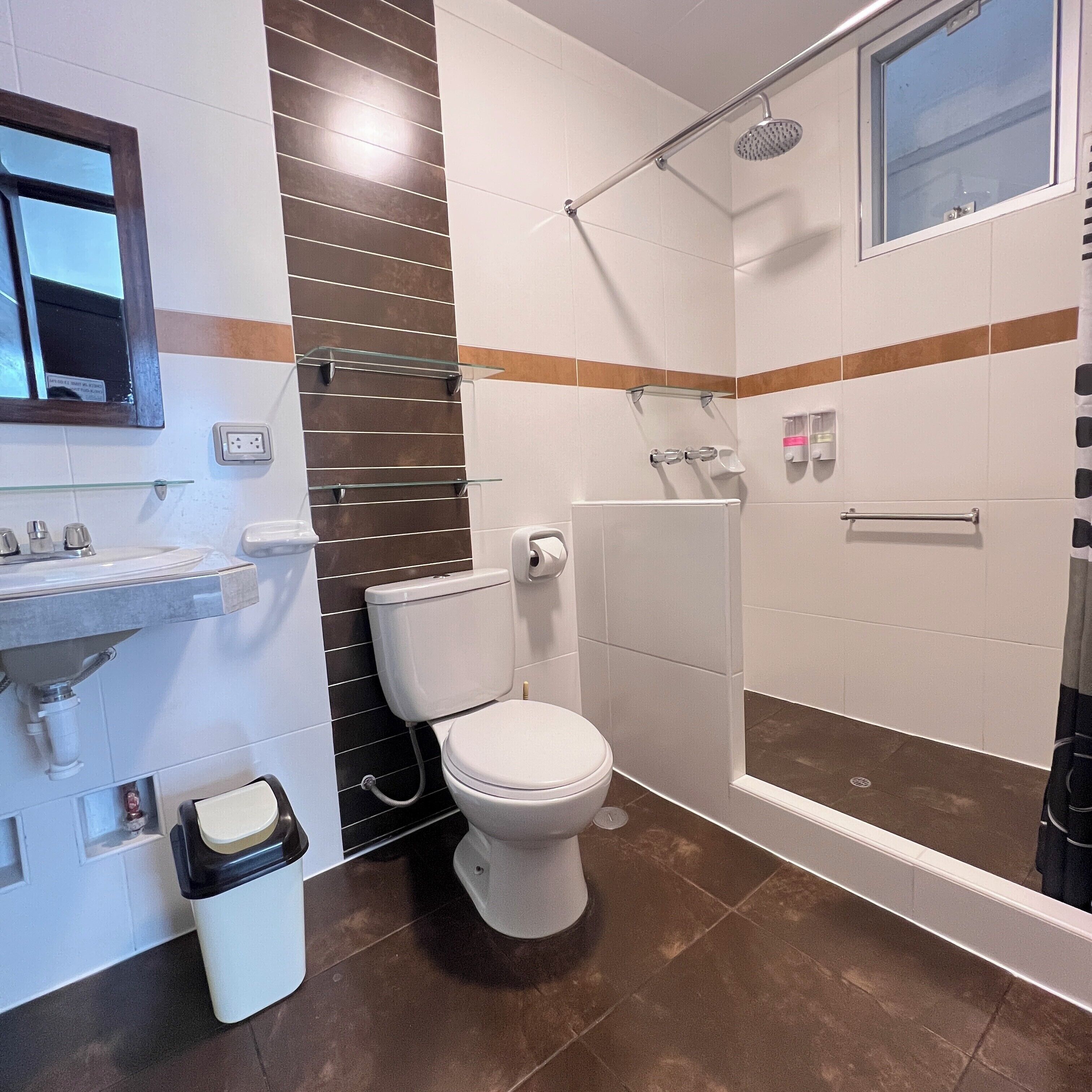 A modern bathroom with a toilet, sink, and shower.