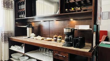 Cozinha equipada com máquina de café, espaço para vinhos e diversos utensílios.