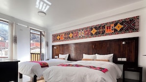 Une chambre d’hôtel avec deux lits, une grande fenêtre et un élément décoratif mural.