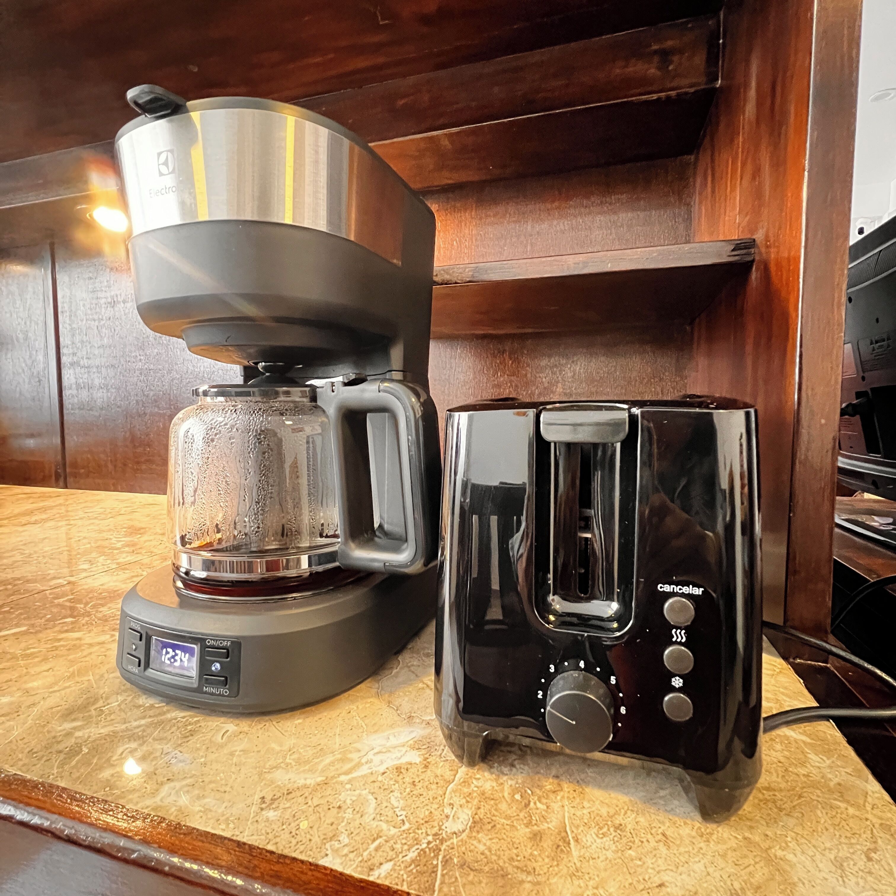 A coffee maker and toaster on a kitchen counter.