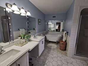 Une salle de bain avec un meuble-lavabo, une baignoire et une douche.