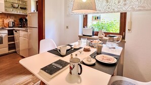 A dining area with a table set for two, a book, and a mug.