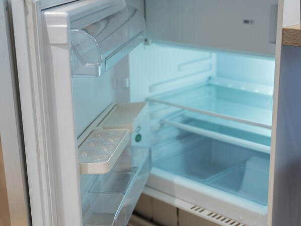 Un réfrigérateur doté d’une porte transparente, d’un distributeur d’eau et d’un bac à glaçons.