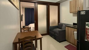 A compact living space with a dining table, chairs, a sofa, a kitchenette, and a ceiling fan. -  1- BEDROOM MARTEL 603 VERDON PARC (Davao City)