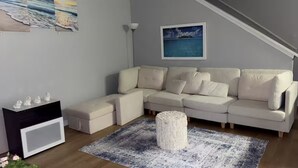En moderne stue med en modulsofa, et lille hvidt skab og et tæppe.