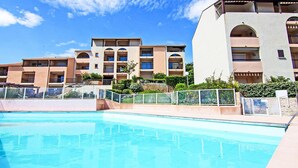 A hotel with multiple balconies, a swimming pool, and a clear blue sky. - La Gaillarde by Interhome (Les Issambres)