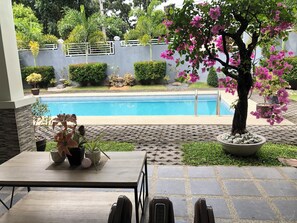 A poolside area with a table, chairs, and a potted plant. - The Villa where you can rent the entire classical villa 700sqm with pool garden. (Angeles)