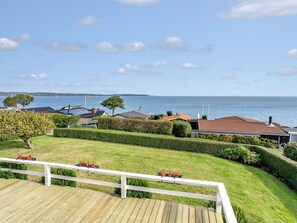 Un quartier résidentiel doté d’une terrasse en bois, de pelouses bien entretenues et de maisons aux toits de différentes couleurs.