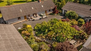 A two-story house with a covered patio and a garden.