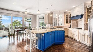 Una cocina amplia con una isla grande, armarios de madera y vistas al exterior.