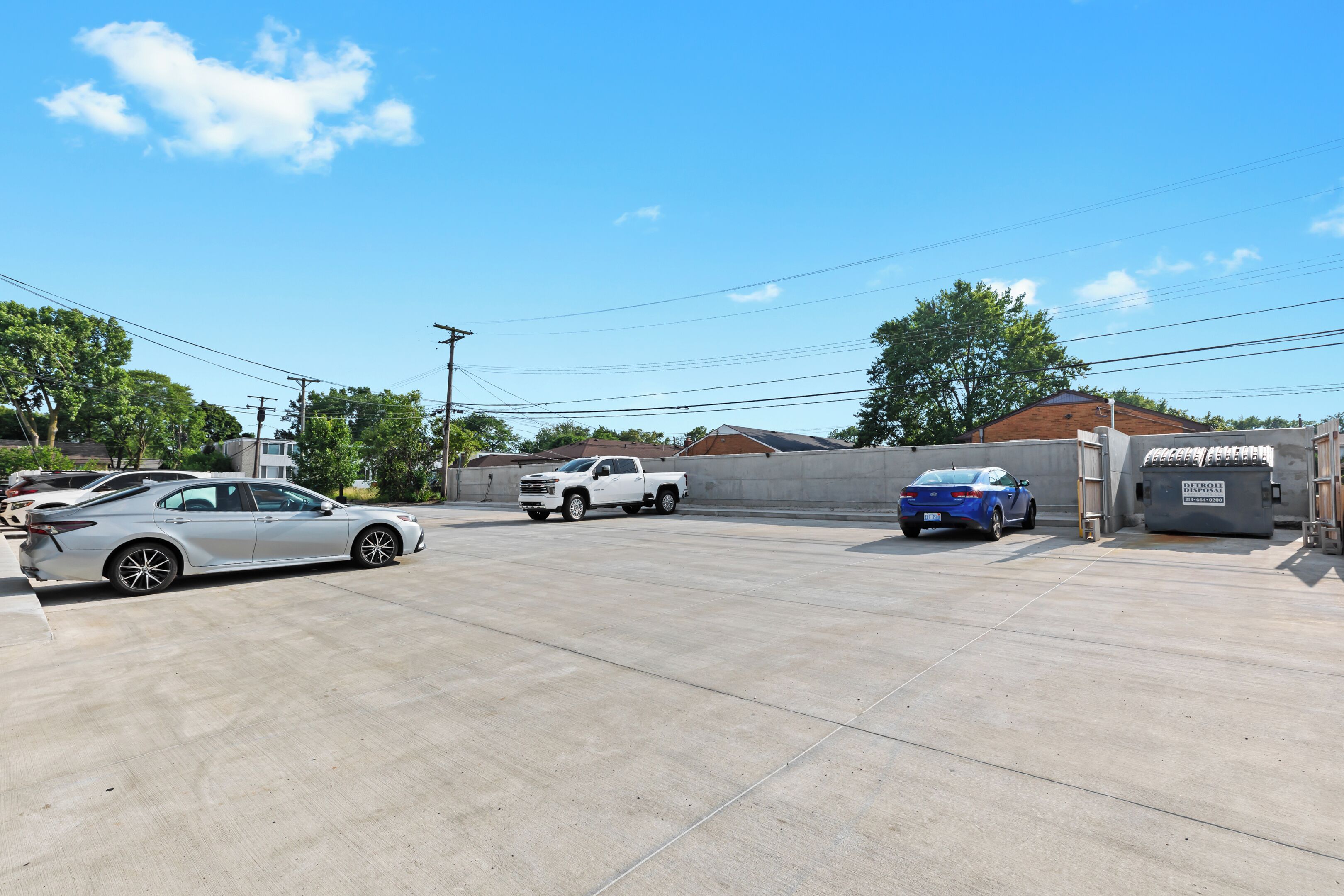 A parking lot with several cars, including a white pickup truck and a blue sedan.