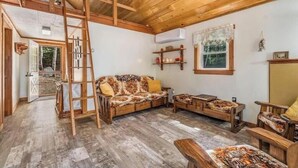 Een rustiek houten interieur met een vide, een bank en een eethoek.