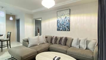 Una sala de estar moderna con un sofá modular, una mesa de centro redonda y un cuadro en la pared.