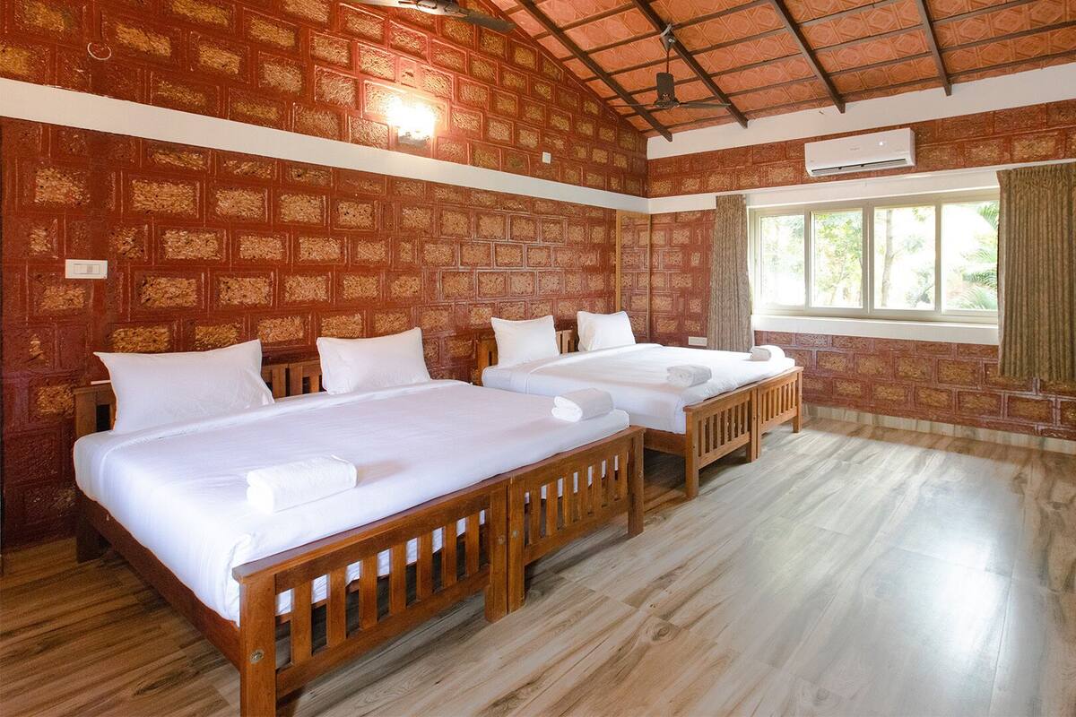 Une chambre avec deux lits en bois, une fenêtre avec des rideaux et une armoire en bois.