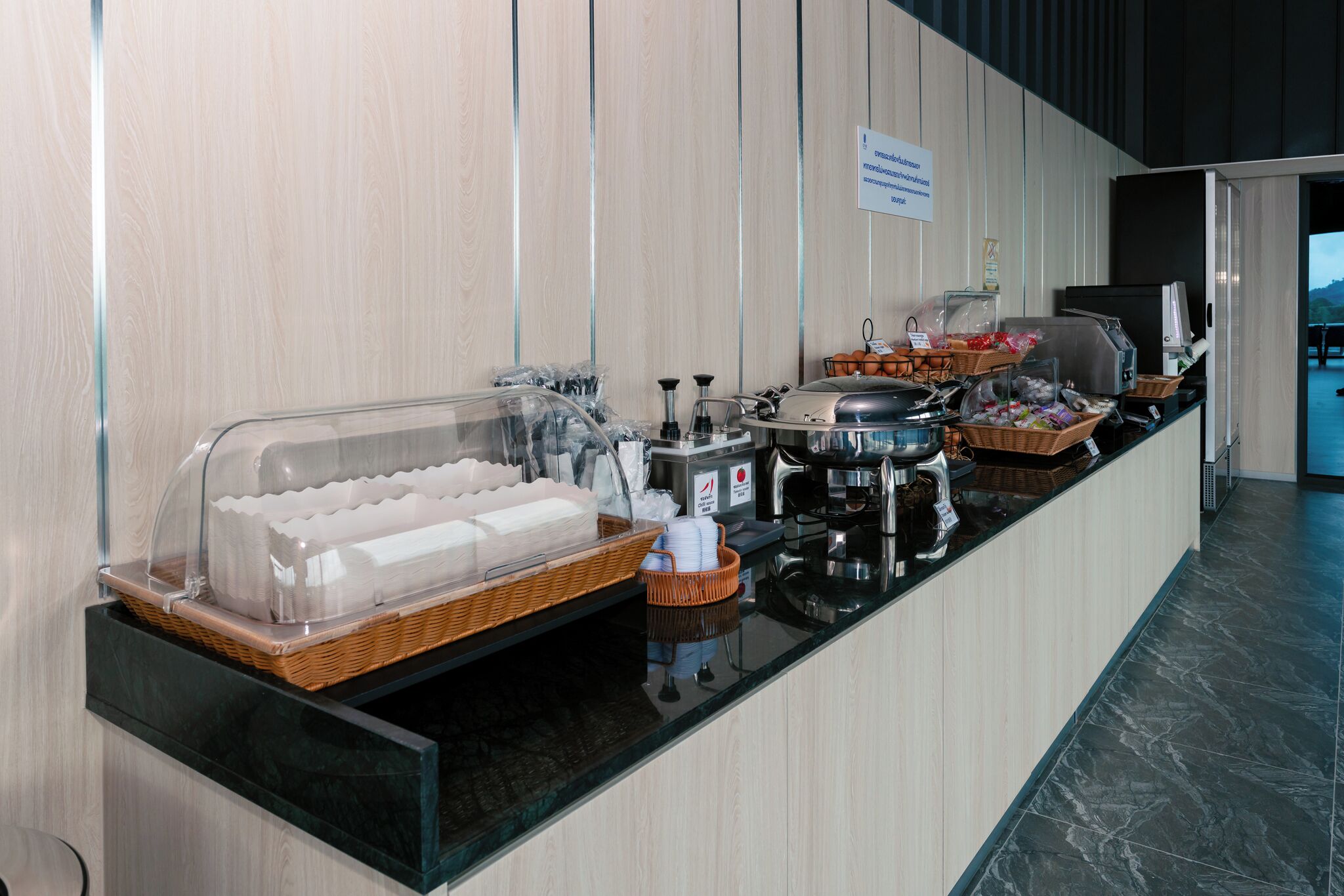 A buffet setup with various food items and a coffee station.