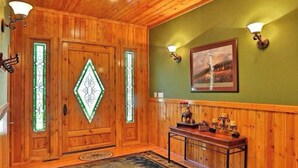 A wooden interior with a large rug, a bench, and two doors with glass panels. - Family-friendly Pinetop cabin on Pinetop Country Club golf course (Pinetop Country Club)