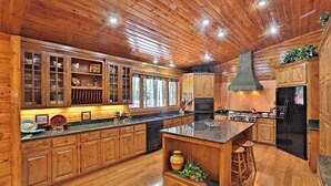 A spacious kitchen with wooden cabinets, a central island, and a large stove. - Family-friendly Pinetop cabin on Pinetop Country Club golf course (Pinetop Country Club)