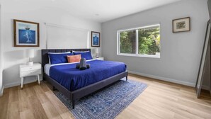 A bedroom with a bed, nightstands, a window, and artwork on the walls. - Villa Venecia | Sand Terrace | Heated Pool | Waterfront (Miami)