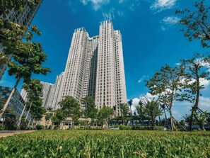A high-rise residential building with multiple floors, surrounded by greenery and other buildings. - Masteri Thao Dien Apartment Complex (Ho Chi Minh)