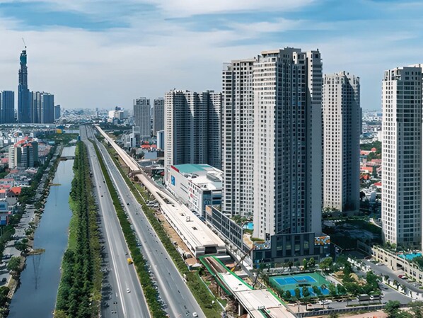 A high-rise urban area with modern buildings, a river running parallel to a highway, and a distant tower. - Masteri Thao Dien Apartment Complex (Ho Chi Minh)