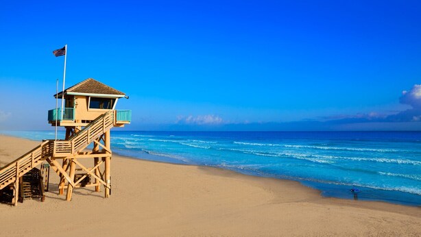 A lifeguard tower on a beach with clear blue skies and ocean waves. - Beach, Don’t Kill My Vibe (Ormond Beach)